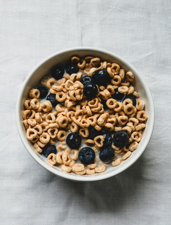 a white bowl filled with cereal and blueberries